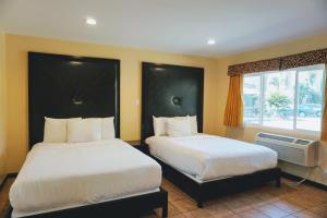 a hotel room with two beds and a window at Casa Bella Inn Downtown LA in Los Angeles