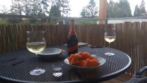 uma mesa com uma garrafa de vinho e uma taça de fruta em Apt.Jana ,apt.Terezka em Stožec