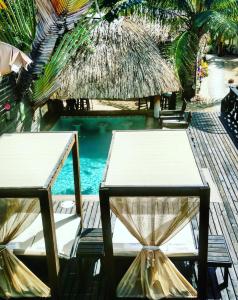 
a wooden table topped with chairs and umbrellas at Caribbean Beach Cabanas - A PUR Hotel in Placencia
