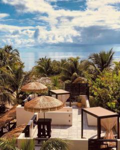 普拉森西亞的住宿－Caribbean Beach Cabanas - A PUR Hotel，一个带桌子和遮阳伞的庭院和大海