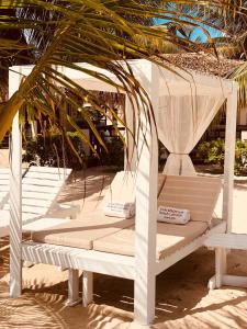 
a white umbrella sitting on top of a wooden bench at Caribbean Beach Cabanas - A PUR Hotel in Placencia
