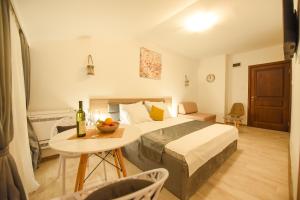 a hotel room with a bed, table, chairs and a television at Korzo apartmani in Podgorica