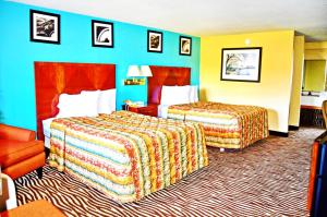 a hotel room with two beds and a chair at Flagship Inn & Suites in Groton