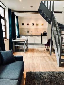 ein Wohnzimmer mit einem Sofa und einem Tisch in der Unterkunft Le Madame Little Appart’Hotel in Lille