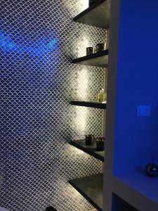a bathroom with a tiled wall with blue lights at MADA Charm Apartments Terrace&Carugio in Vernazza