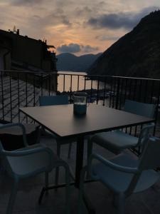 a table with chairs and a candle on a balcony at MADA Charm Apartments Terrace&Carugio in Vernazza