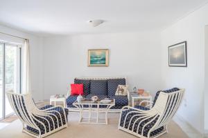 a living room with two chairs and a couch at Luxury 6BR Villa, Garden Oasis, near Schinia Beach in Káto Soúlion