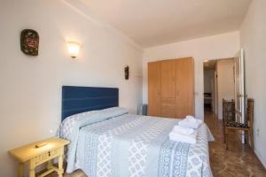 1 dormitorio con cama azul y mesa de madera en Alicante central and beach side apartment, en Alicante