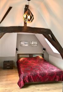 - une chambre mansardée avec un lit rouge dans l'établissement Le Madame Little Appart’Hotel, à Lille