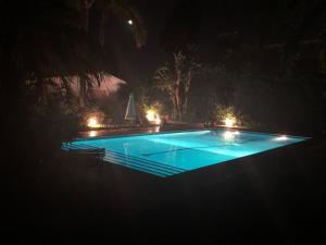 a swimming pool lit up at night with lights at Domus Orestea Luxury Suites in Palermo