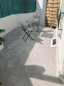 eine Terrasse mit einem Tisch und Stühlen auf einem Fliesenboden in der Unterkunft BtoBed - Studios Paris Le Bourget in Le Bourget