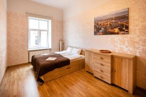 ein Schlafzimmer mit einem Bett, einer Kommode und einem Fenster in der Unterkunft Old Riga Quiet Apartment in Riga