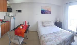 Habitación pequeña con cama, mesa y cocina en Aguero y Av. Las Heras en Buenos Aires