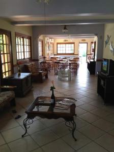 uma grande sala de estar com mesa e cadeiras em Hotel Canto da Enseada no Guarujá