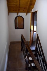 Habitación con escalera, espejo y puerta. en Cabañas Antu Kuyen en Las Gaviotas