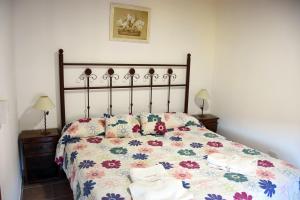 1 dormitorio con 1 cama con colcha de flores en Cabañas Antu Kuyen en Las Gaviotas