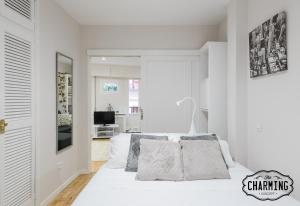 a white bedroom with a white bed with pillows at Charming Mercado de San Miguel in Madrid