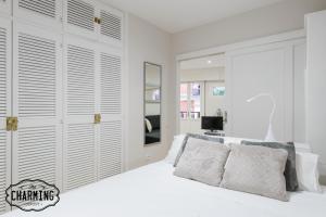 1 dormitorio con paredes blancas y 1 cama blanca con almohadas en Mercado de San Miguel - Apartamento de 1 dormitorio, en Madrid