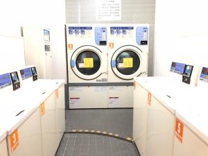 two washing machines in a laundry room with counters at Hotel Mirai in Yokohama