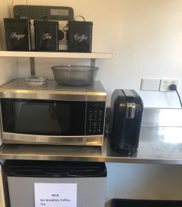 un four micro-ondes et un grille-pain sur un comptoir dans l'établissement Cambridge Lodge, à Sydney