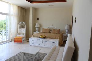 1 dormitorio con 1 cama y sala de estar en Puerta del Mar Cozumel en Banco Playa