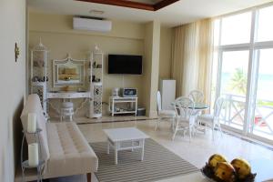 una sala de estar con un sofá y una mesa en Puerta del Mar Cozumel, en Banco Playa