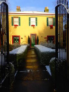 une maison jaune avec une porte dans la neige dans l'établissement Blakes Manor Self Contained Heritage Accommodation, à Deloraine