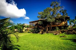 una casa con un patio de hierba delante de ella en Cabañas Tokerau en Hanga Roa