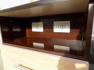 a drawer with two outlets in a wooden cabinet at Meridiano68 Apartment in Ushuaia