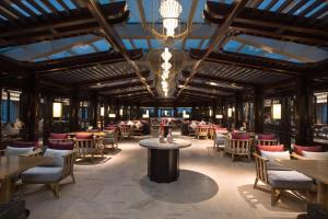 a restaurant with tables and chairs and a chandelier at Ascott Riverside Garden Beijing in Beijing