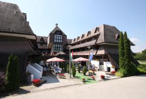 a building with tables and chairs in front of it at Viking Hotel in Gárdony