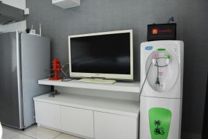 a computer sitting on top of a desk with a tv at Modern and Comfortable Studio Apartment Springlake Summarecon near Summarecon By Travelio in Bekasi