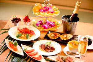 京都市にあるホテル　アンド　スパ　ロータス　モダン （大人専用）の食べ物の皿とワインのボトルが置かれたテーブル
