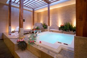 La salle de bains est pourvue d'une grande baignoire avec des plantes. dans l'établissement Hotel and Spa Lotus Modern (Adult Only), à Kyoto