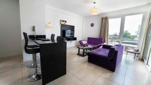 sala de estar con sofá púrpura y escritorio en Condo-Apart Nordelta Wyndham- loft en Tigre