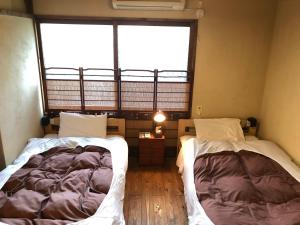 直島町にあるゲストハウス路地と灯りの大きな窓付きの客室で、ベッド2台が備わります。