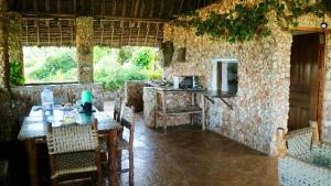 a kitchen with a table and chairs in a building at Mango Lodge MSAMBWENI in Kisimachande