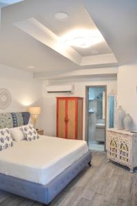 a bedroom with a large bed and a bathroom at Le Castel Blanc Hotel Boutique in San Andrés