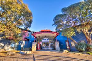 un edificio blu con alberi di fronte di The River Inn Thredbo a Thredbo