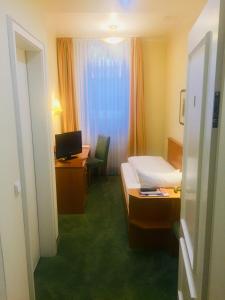 フランクフルト・アム・マインにあるホテル ベートーベンのベッド、デスク、コンピュータが備わるホテルルームです。