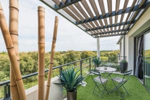a patio with a table and chairs on a balcony at Appartement de L'Espiguette in Le Grau-du-Roi