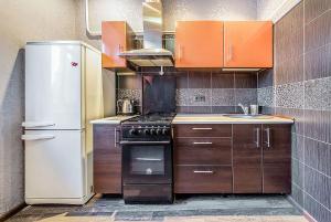 kuchnia z brązowymi szafkami i białą lodówką w obiekcie Apartment on Karl Marx Street w Mińsku