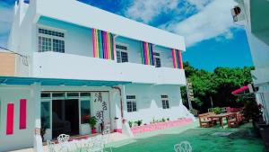 a white building with colorful stripes on the side of it at Ching Ji Ming Inn in Kenting
