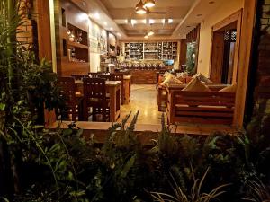 a restaurant with wooden tables and chairs and plants at Hotel Middle Path & Spa in Pokhara