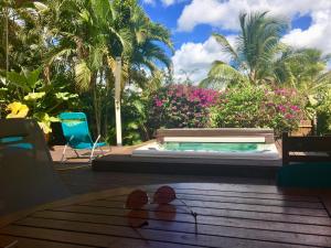 une paire de chaussures assise sur une table à côté d'une piscine dans l'établissement La Villa Des Tropiques - Turquoise, à Les Trois-Îlets