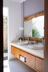 a bathroom with two sinks and a mirror at Silversand Villa in Tanah Lot