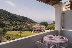 einen Tisch und Stühle auf einem Balkon mit Aussicht in der Unterkunft Villa Anneta in Vitalades