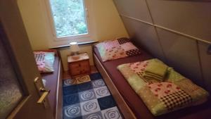 2 Betten in einem kleinen Zimmer mit Fenster in der Unterkunft Ferienhaus Zum See in Perlin