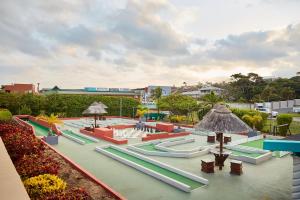 una piscina con mesas, sillas y sombrillas en First Group Club Hacienda en Shelly Beach