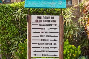 a sign for a club margarita in a garden at First Group Club Hacienda in Shelly Beach